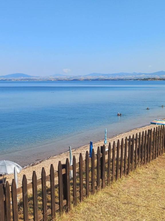 a fence on a beach with the water at By the sea in Nea Potidaea