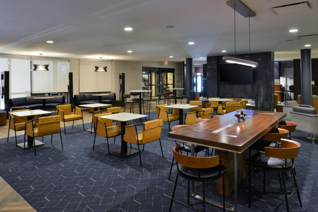 a restaurant with tables and chairs and a tv at Courtyard by Marriott Harrisburg Hershey in Harrisburg