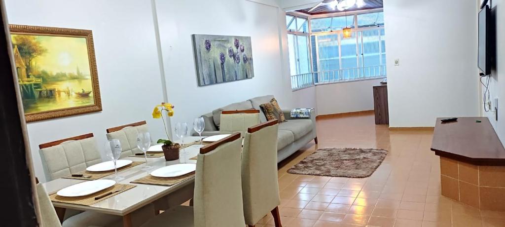 a dining room with a table and a couch at Apto 3 Quartos com Suíte e 3 Banheiros em Guarapari in Guarapari