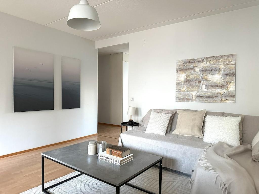 a living room with a couch and a table at 3BR w balconies and private sauna in Helsinki