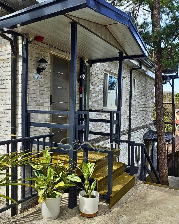 ein winziges Haus mit blauem Dach und Treppe in der Unterkunft Sanjang Guest House in Baguio City
