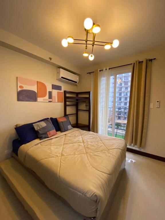 a bedroom with a large bed with a large window at Z and R Haven in Lapu Lapu City