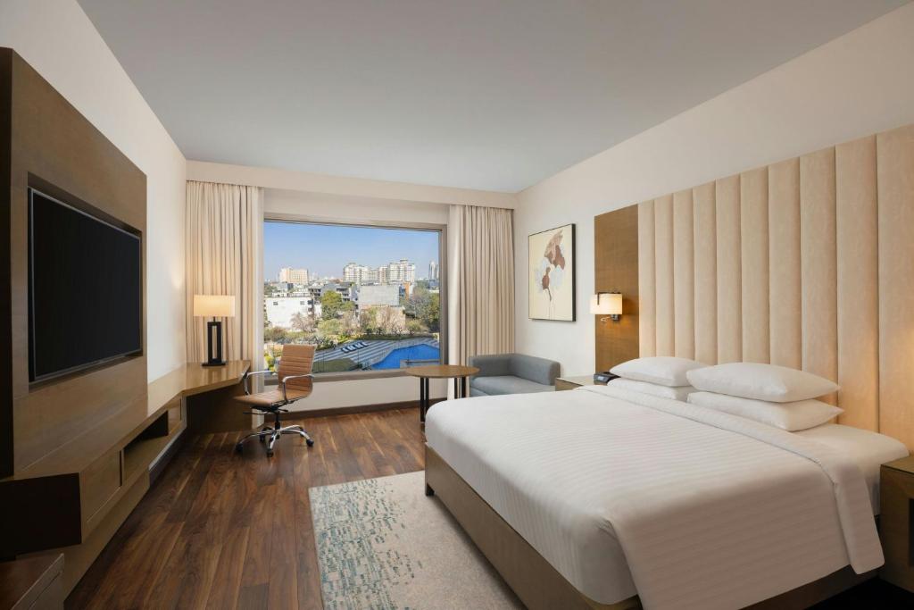 a hotel room with a bed and a television at Courtyard by Marriott Gurugram Downtown in Gurgaon