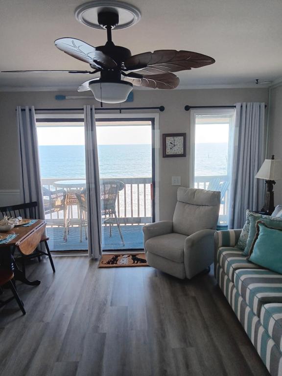ein Wohnzimmer mit einer Couch und einem Deckenventilator in der Unterkunft Shore Tails, LLC in Myrtle Beach