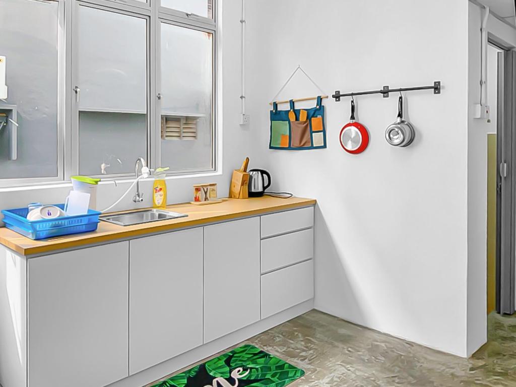 a kitchen with white cabinets and a sink at Yong Peng homestay 永平民宿- 3 Bedroom Shoplot converted BnB at level 1 &2, for business travellers, Street Parking, WIFI, 1 min to KFC & MCD in Yong Peng