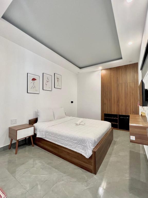 a bedroom with a bed and a wooden cabinet at Cassie Boutique Hotel in Vung Tau
