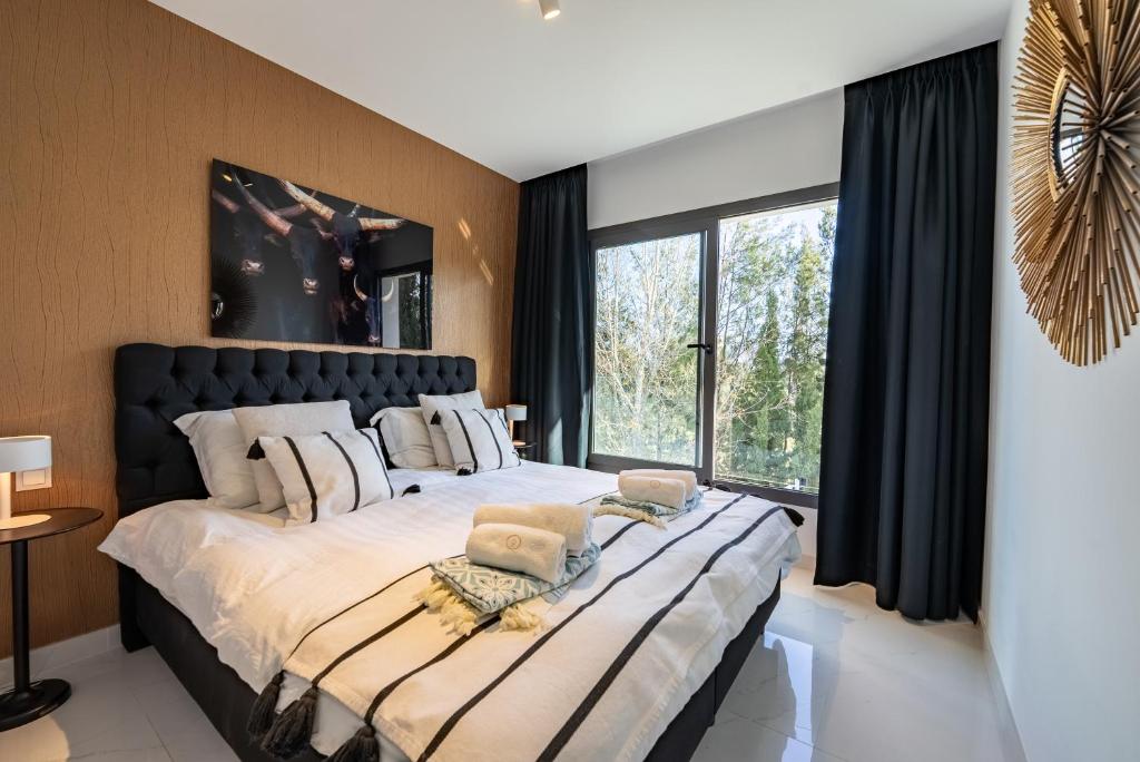sypialnia z dużym łóżkiem i dużym oknem w obiekcie Marbella GOLF & SEA LODGE w mieście Estepona
