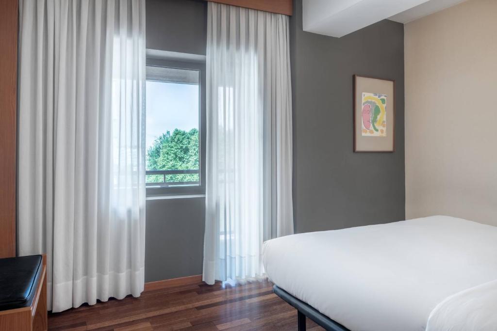 A bed or beds in a room at AC Hotel Ponferrada by Marriott