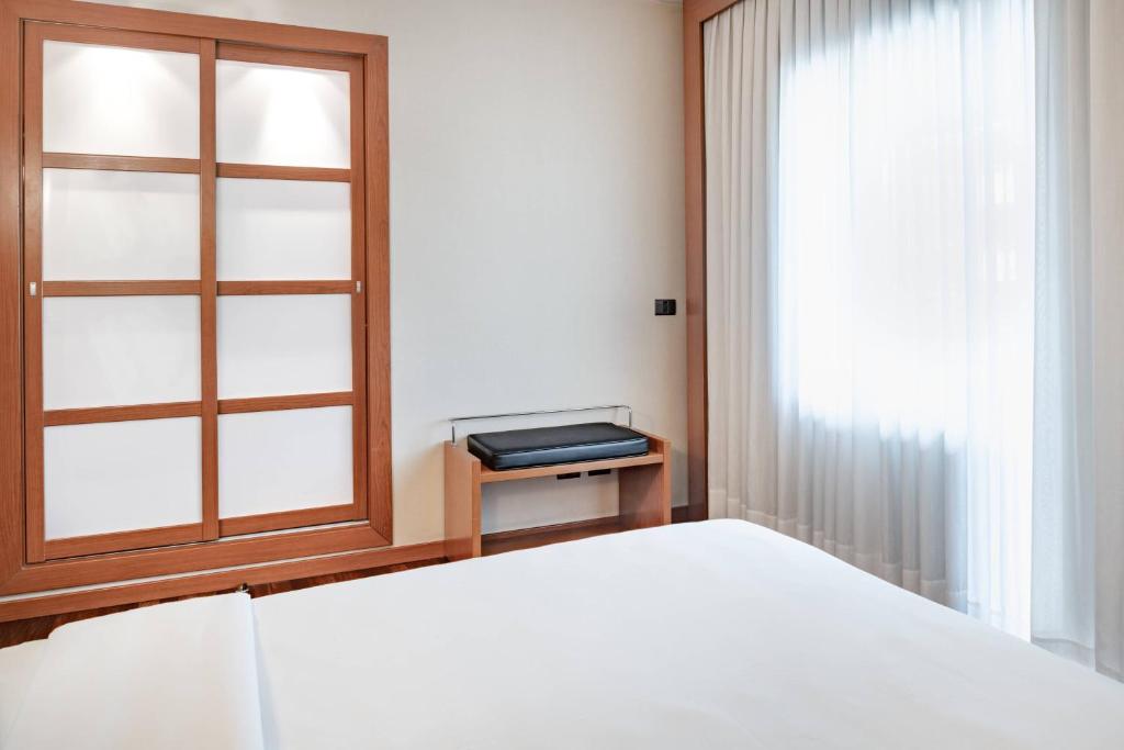 A bed or beds in a room at AC Hotel Ponferrada by Marriott
