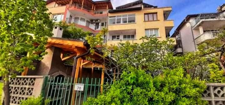 a house with a fence in front of a building at Family Hotel Magnolia - Summer residence in Primorsko