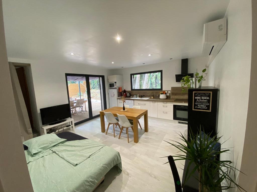 un salon avec une table et une cuisine dans l'établissement Appartement en campagne, à Saint-Marcel-de-Carreiret