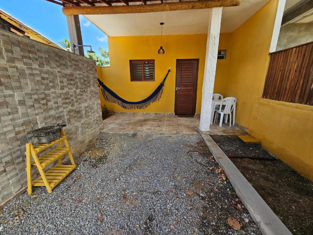 eine Außenansicht eines Hauses mit gelber Wand in der Unterkunft Sol & Vento Chalés - Chalé Cardeiro in São Miguel do Gostoso