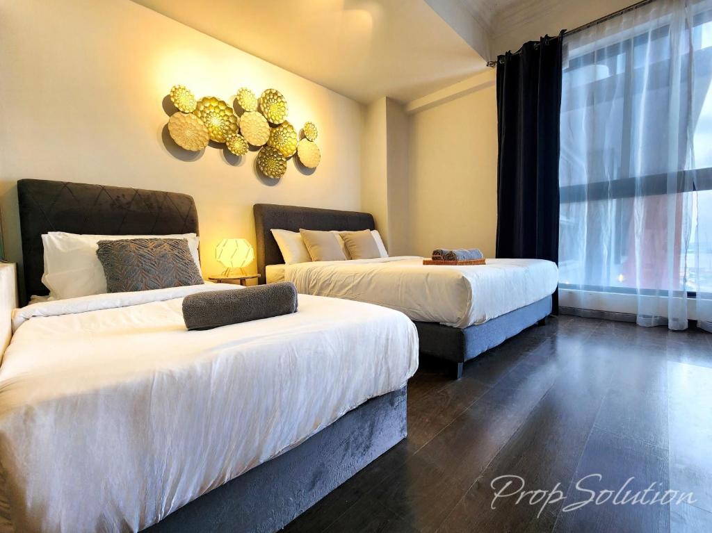 a bedroom with two beds and a window at Loft Suite Central City 2BR JB CIQ 7Pax in Johor Bahru