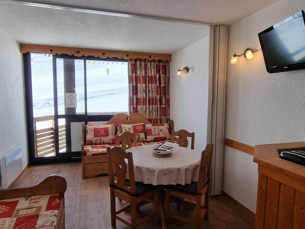 un salon avec une table et un salon avec vue dans l'établissement Studio lumineux au pied des pistes avec balcon exposé Sud - FR-1-181-2568, à Aime La Plagne