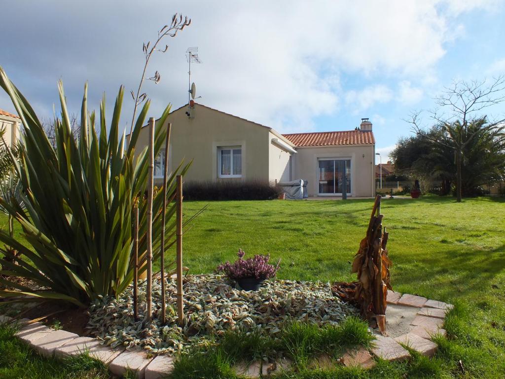 une maison avec un jardin en face d'une cour dans l'établissement Maison Familiale à St-Brevin - Confort & Sérénité, à Saint-Brévin-les-Pins