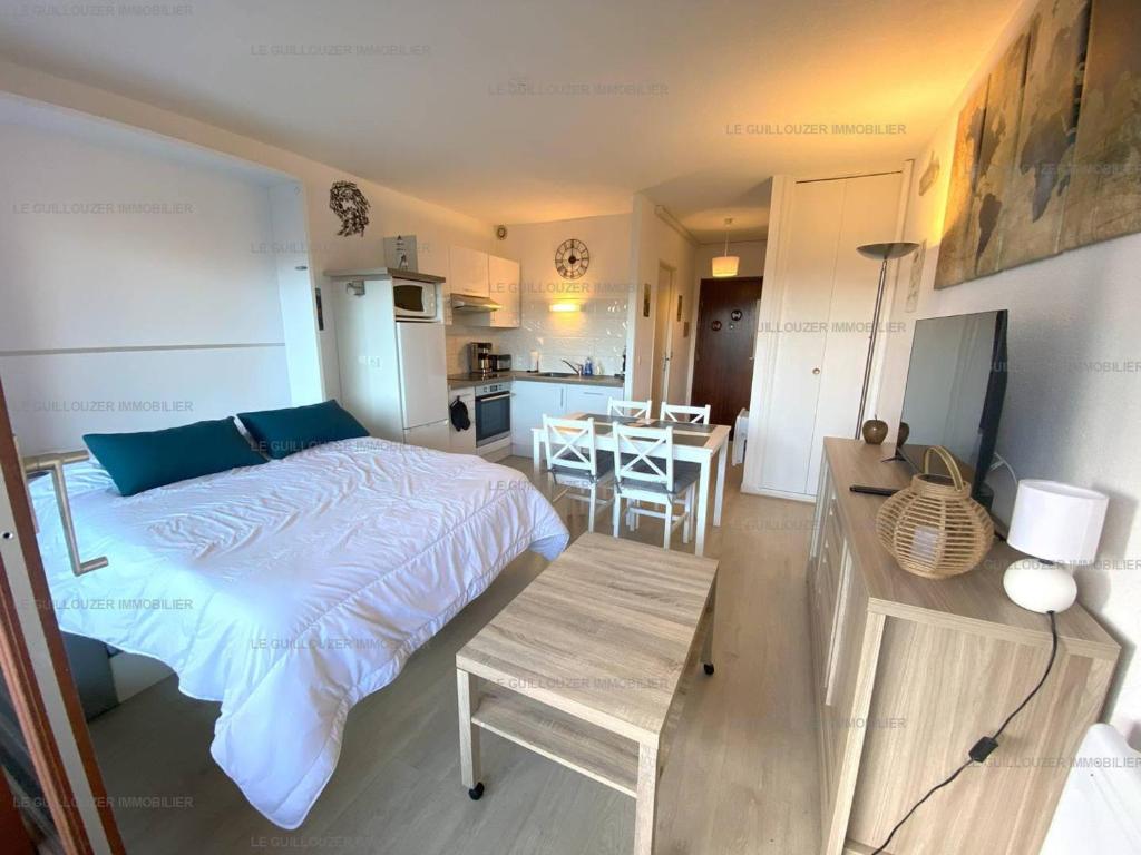 une chambre avec un lit et une table et une cuisine dans l'établissement Appartement calme avec balcon, parking, près du port de Perros-Guirec - FR-1-368-412, à Perros-Guirec