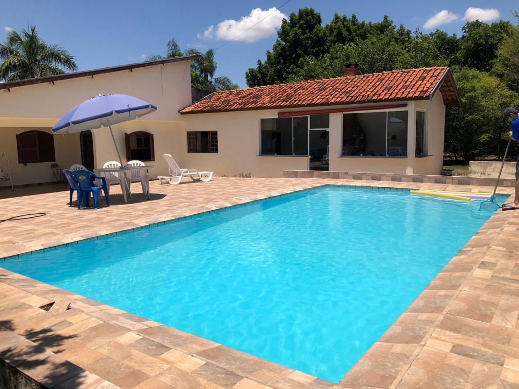 a swimming pool in front of a house at Chácara em São Pedro com piscina e churrasqueira in São Pedro
