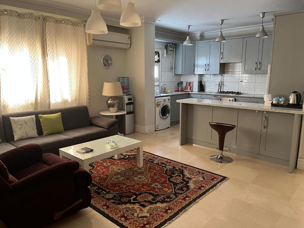 a living room with a couch and a table at Cosy & central 2 bedroom apartment in 6th Of October