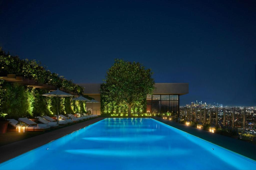 - une piscine de nuit avec un bâtiment dans l'établissement The West Hollywood EDITION, à Los Angeles