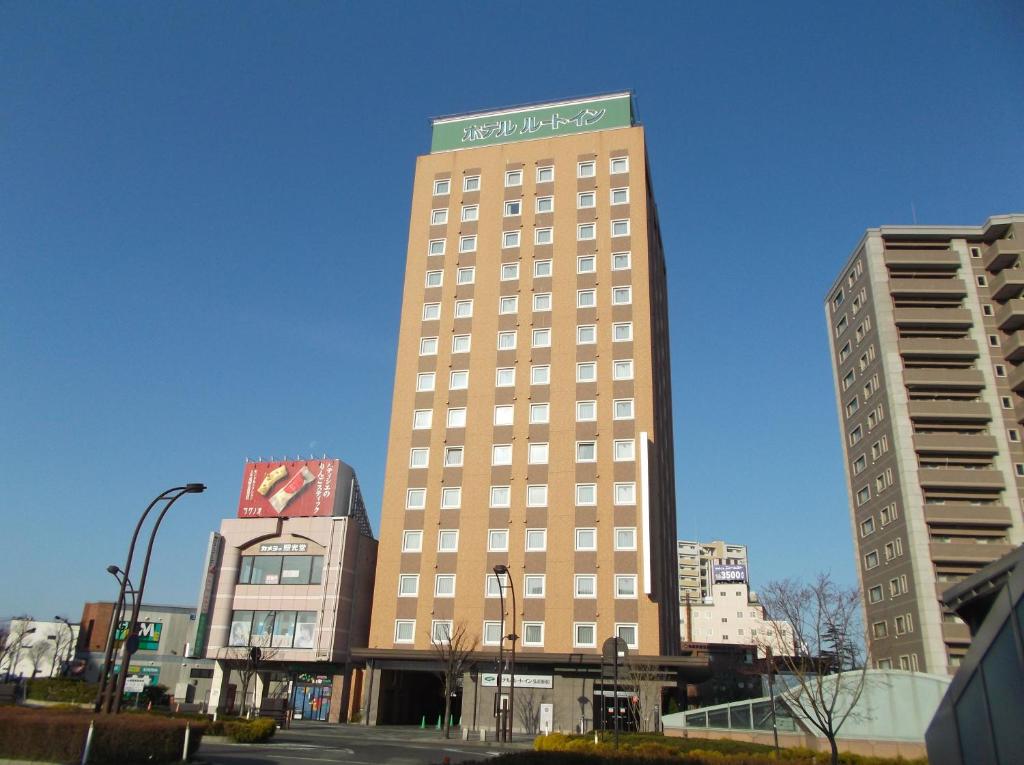 
a tall building with a large clock on it's side at Hotel Route-Inn Hirosaki Ekimae in Hirosaki
