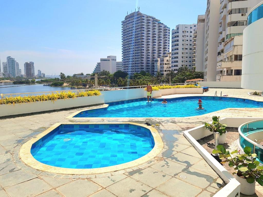 a large swimming pool in a city with buildings at Laguito Apartment in Cartagena de Indias