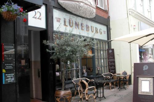 a restaurant with tables and chairs in front of a building at Lüneburg Haus in Kiel