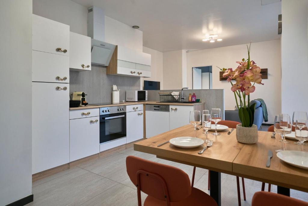 une cuisine et une salle à manger avec une table et des chaises en bois dans l'établissement L'ADREÏA Confortable T2 - Rénové - Lumineux - Calme - Parking - proche Lille & Tramway, à Marcq-en-Barœul