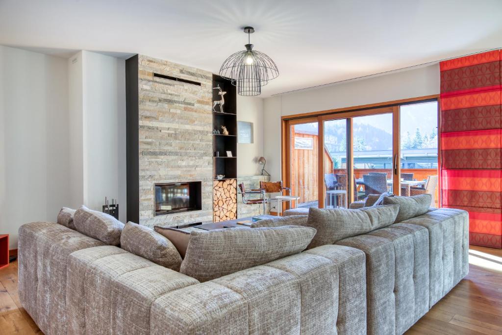 eine große Couch in einem Wohnzimmer mit Kamin in der Unterkunft Lodge 8 next to ski lift and sportcenter in Champéry