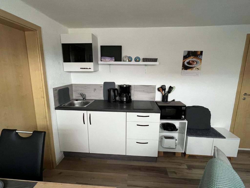 a small kitchen with white cabinets and a sink at Ferienwohnung Jardin de lavande in Fridingen an der Donau