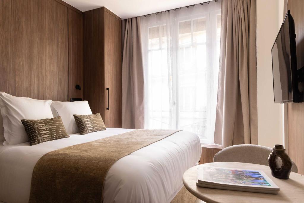 une chambre d'hôtel avec un lit, une table et une fenêtre dans l'établissement Charming Studio climatisé - 2P- Madeleine, à Paris