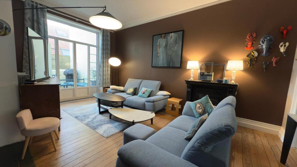 un salon avec un canapé bleu et des chaises dans l'établissement Villa Sainte Rosalie, à Wimereux