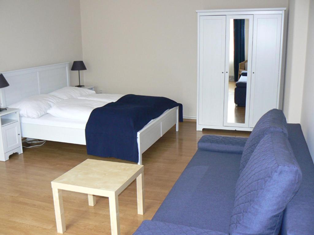 a bedroom with a bed and a couch and a table at Apartmán U krále Tylova 516 in Jičín