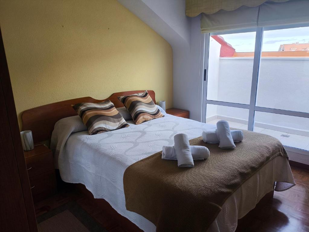 a bedroom with a bed with two towels on it at Apartamento entreplayas Los Espejos in Noja