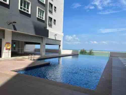 an external view of a building with a swimming pool at SURIA HomeStay Kuala Terengganu City Center, 8 pax, 150M to KTCC Mall in Kuala Terengganu