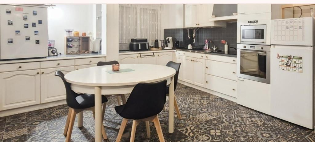 LocminéにあるMaison individuelle centreの白いキッチン(テーブル、椅子付)