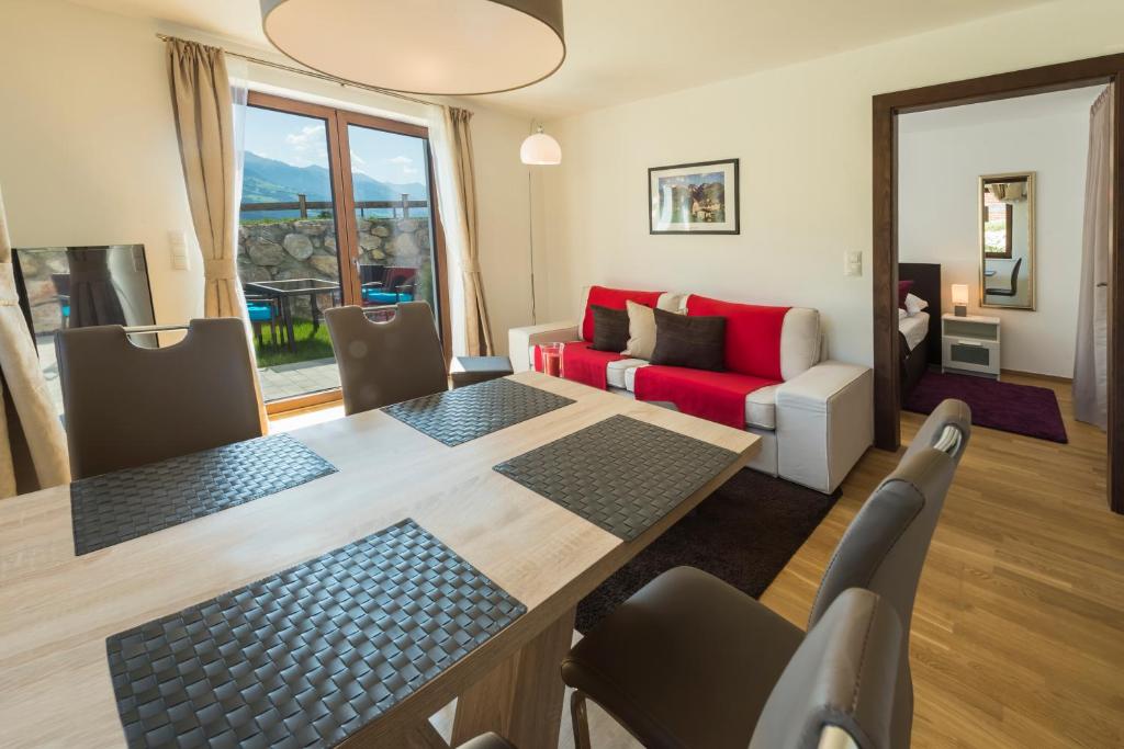 ein Wohnzimmer mit einem Tisch und einem roten Sofa in der Unterkunft Appartement Klausner in Kitzbühel