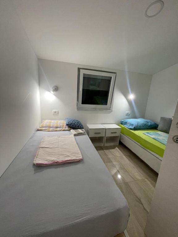 a bedroom with two beds and a tv on the wall at Vila White Pearl in Vir