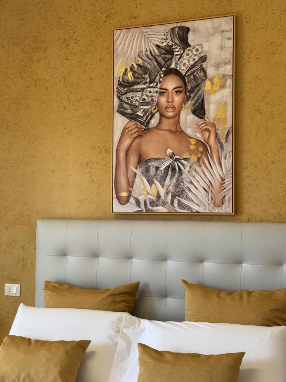 una pintura de una mujer en una pared sobre una cama en Crispi 120 Rooms New Opening, en Palermo