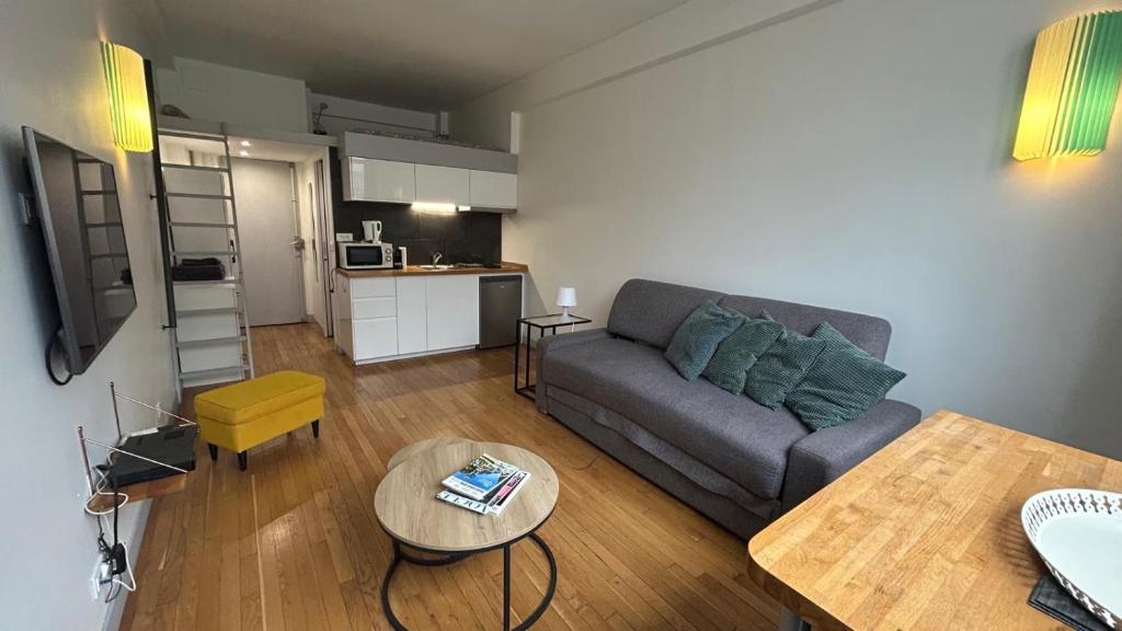 un salon avec un canapé et une table dans l'établissement Superbe appartement 4 personnes au centre de Paris, à Paris