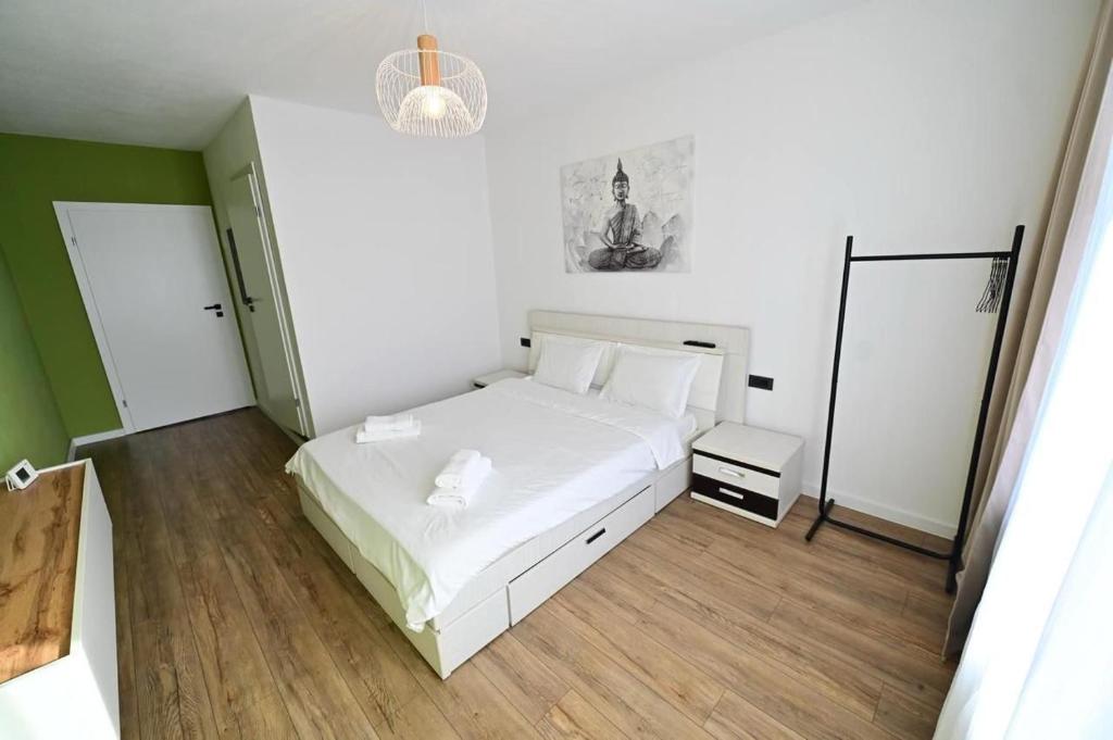 Un dormitorio con una cama blanca y un espejo. en Old Town Ruby, en Sibiu