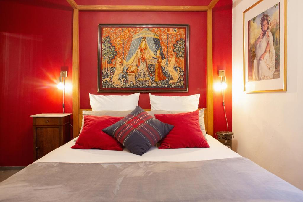 une chambre avec des murs rouges et un lit avec des oreillers rouges dans l'établissement HARRY POTTER A LA PLAGE, à Toulon