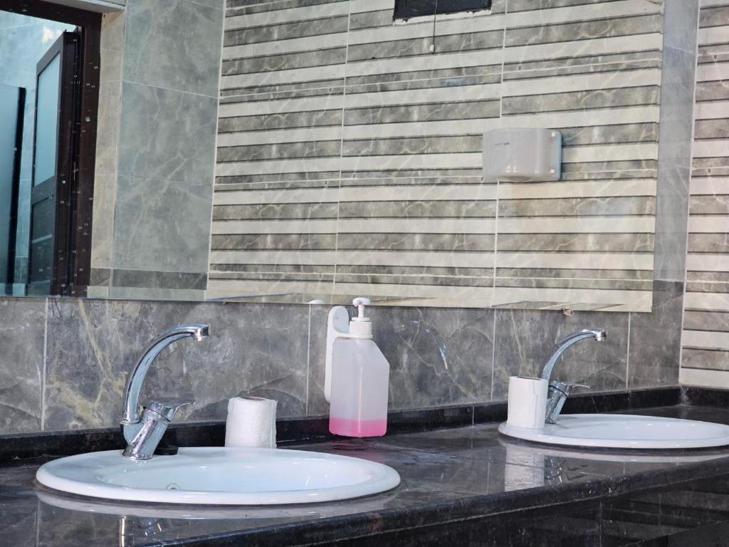 two sinks in a bathroom with a pink soap bottle at RUM CITY STAR BUBBLE lUXURY CAMP in Wadi Rum