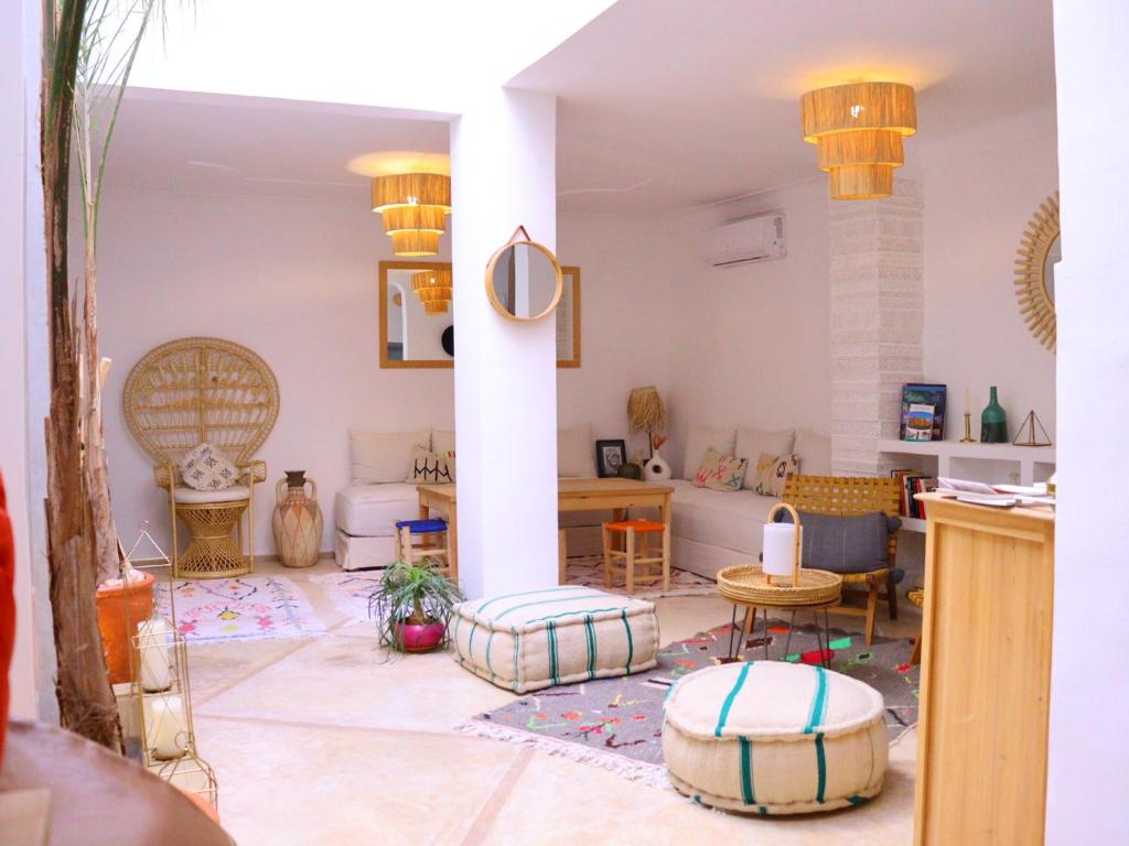a living room with a column and a table and chairs at Riad Dar Fena By K&G &jacuzzi in Marrakech