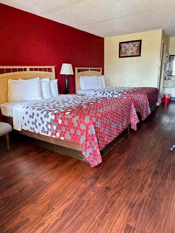 a bedroom with two beds and a red wall at Econo Lodge Christiansburg-Blacksburg I-81 in Christiansburg