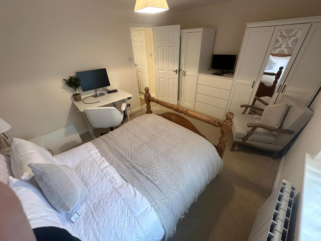 a bedroom with a bed and a desk with a computer at Cosy 2 Bed House near Birmingham Airport & NEC in Birmingham