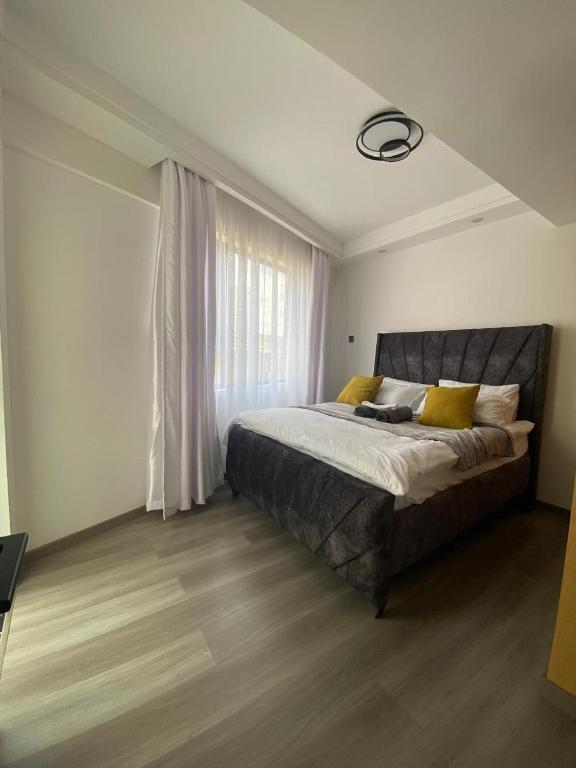 a bedroom with a large bed and a window at Sapphire in Nairobi