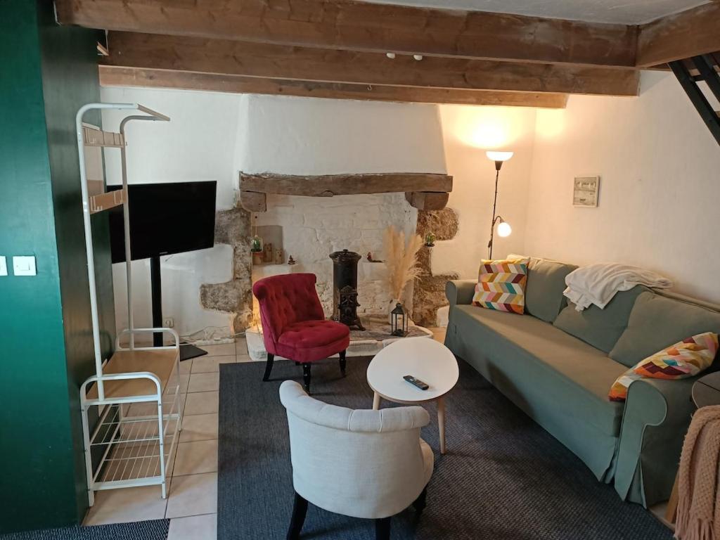 a living room with a green couch and a fireplace at "Le Coeur de Berrien" Gite familial proche Huelgoat Monts d'Arrée in Berrien