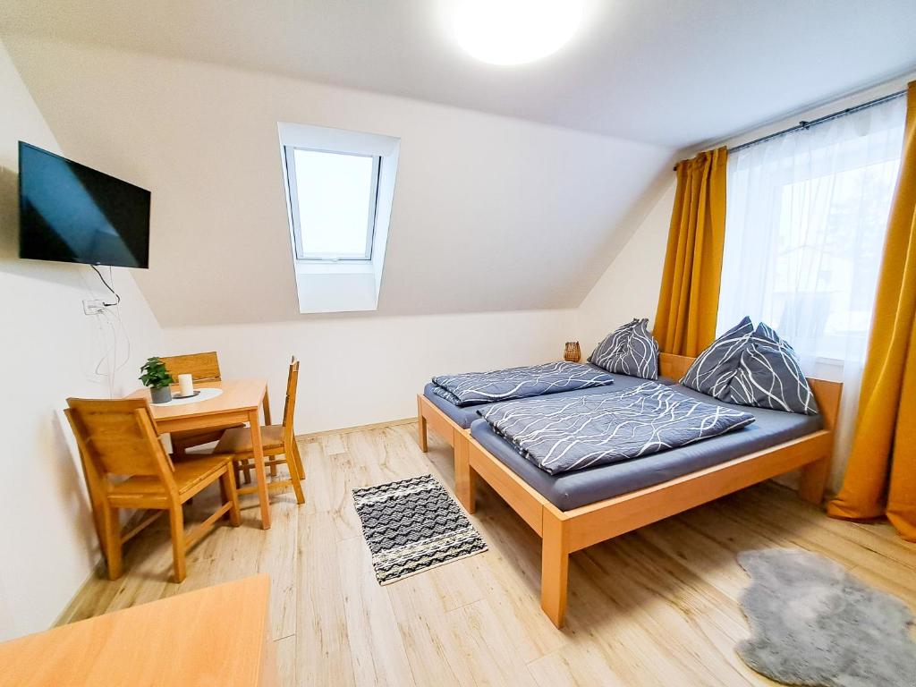 a small bedroom with a bed and a dining table at SK family - Ubytování v rodinném domě in Týn nad Vltavou
