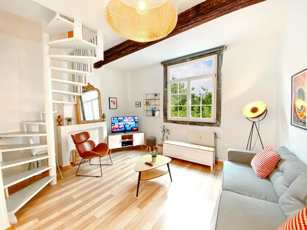 a living room with a couch and a table at Les Cerisiers - Duplex de Standing au Centre de Namur in Namur
