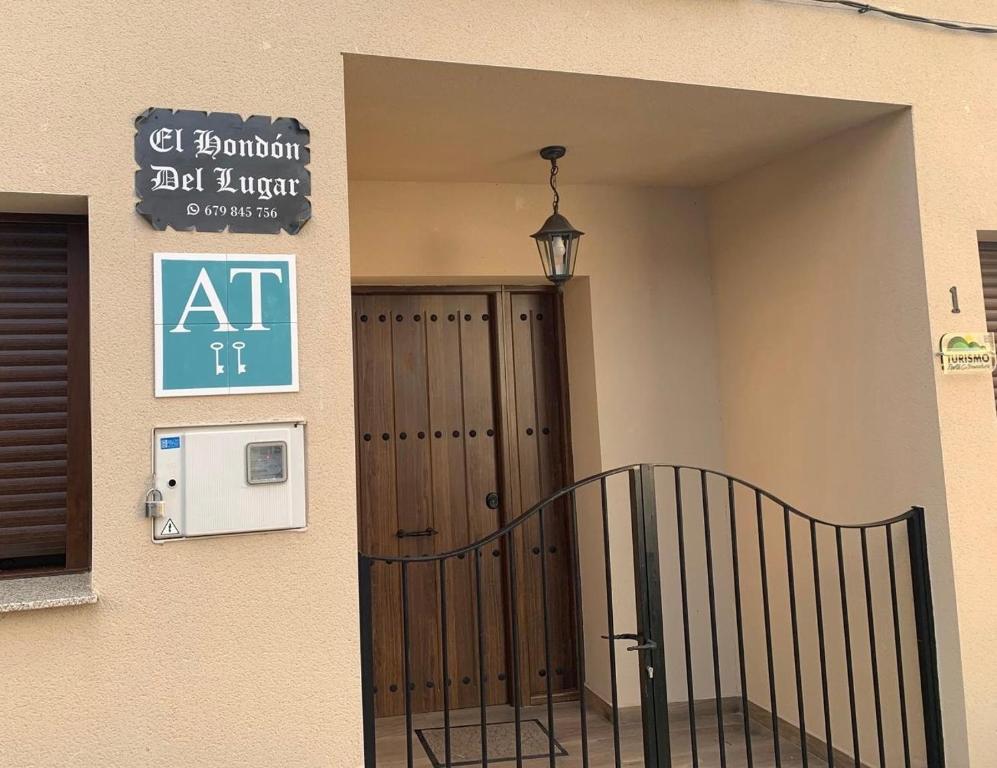 an entrance to a building with a door and a sign at El Hondón del Lugar in Hoyos